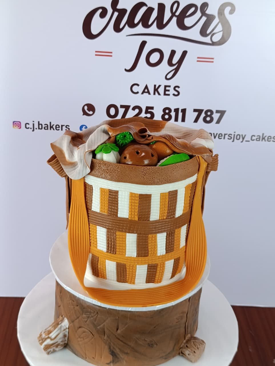 Cake sculpted as a woven basket filled with produce, sitting on a fondant tree stump.