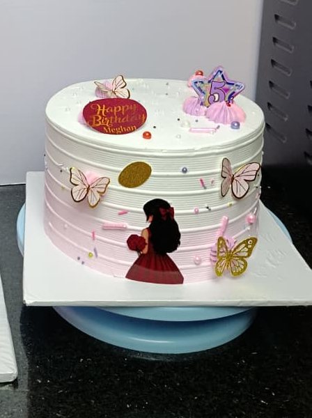 Children's cake decorated with butterflies, a silhouette topper and a name plaque.