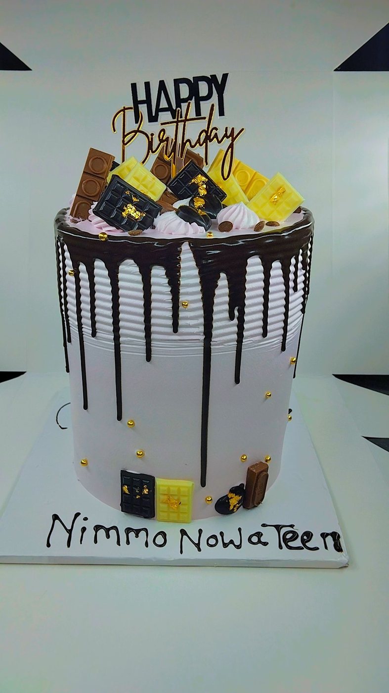 Tall chocolate drip cake loaded with chocolate slabs and meringues.